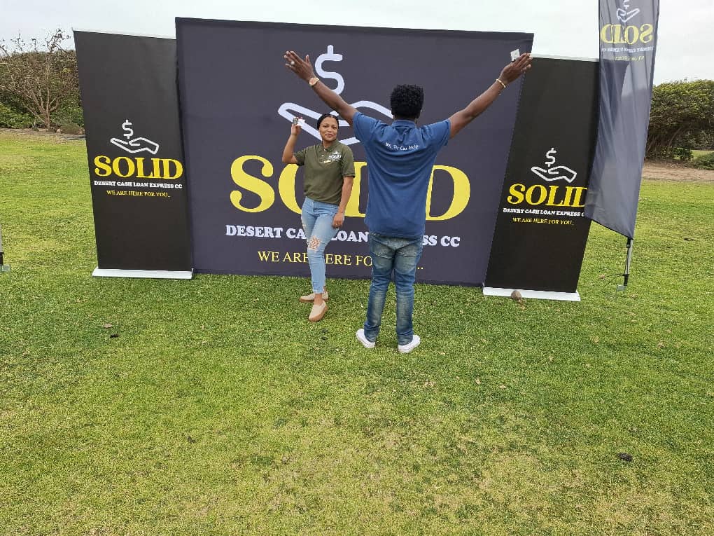 Woman and man posing with banners