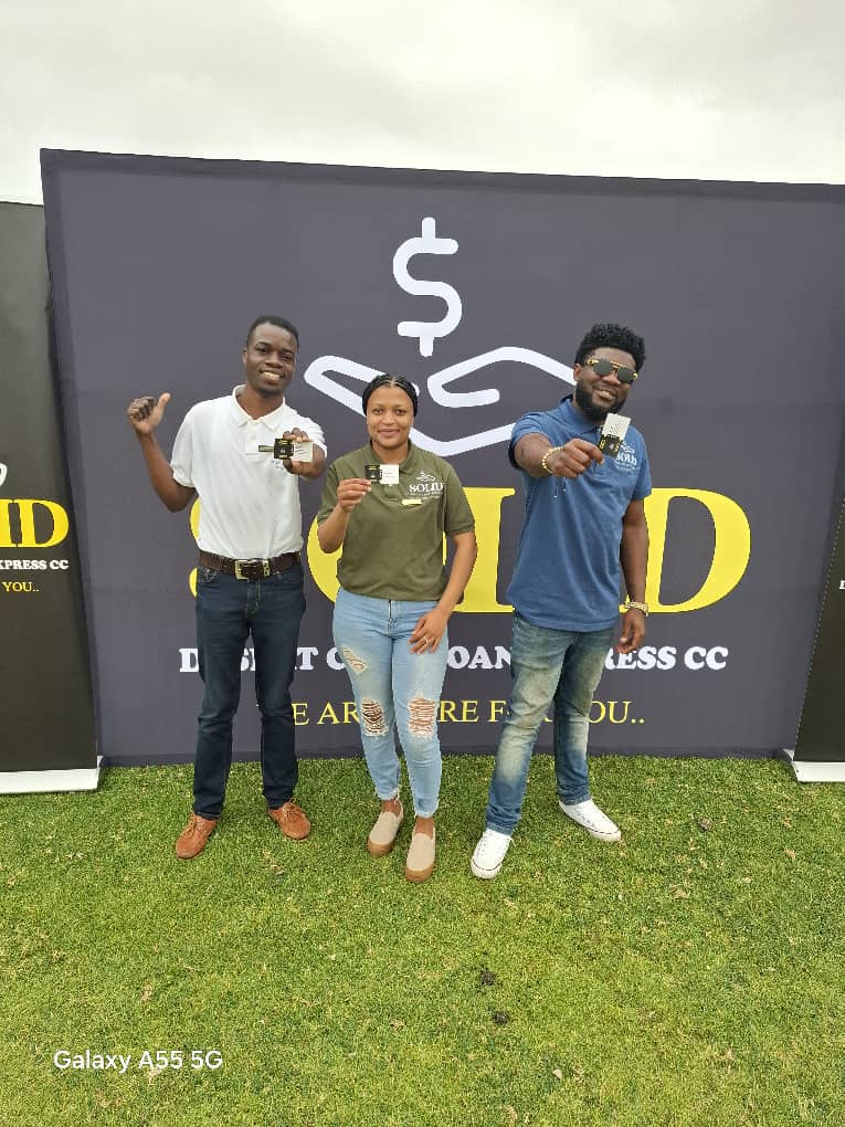 Three people holding branded cards