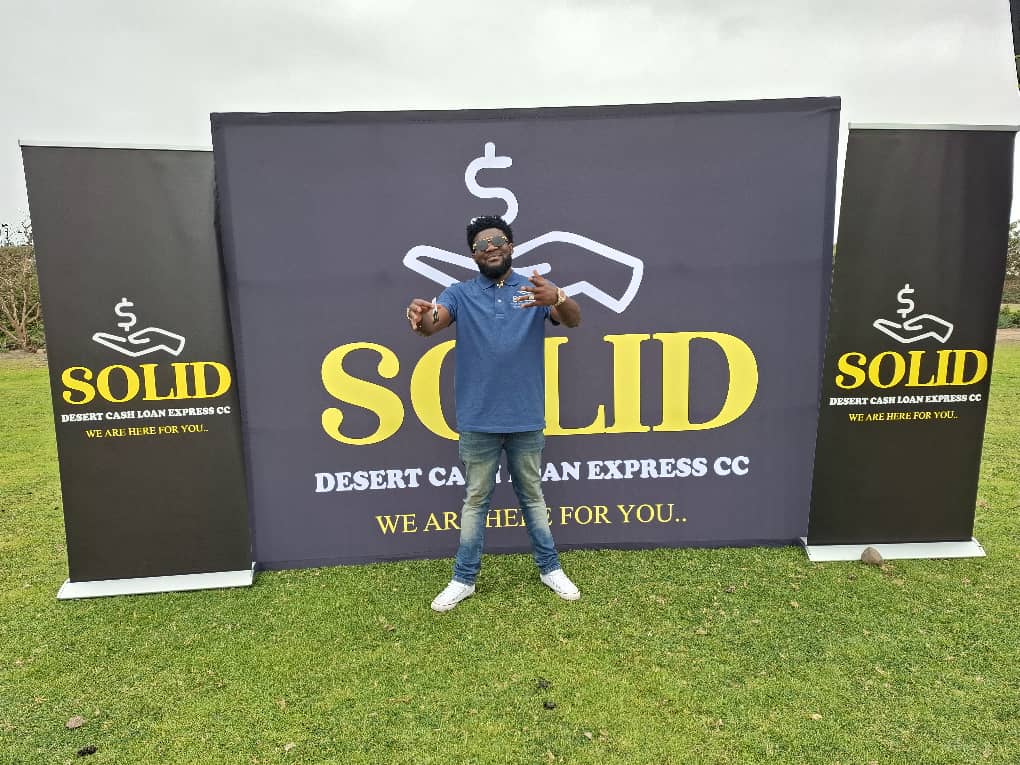 Team member posing with company banners