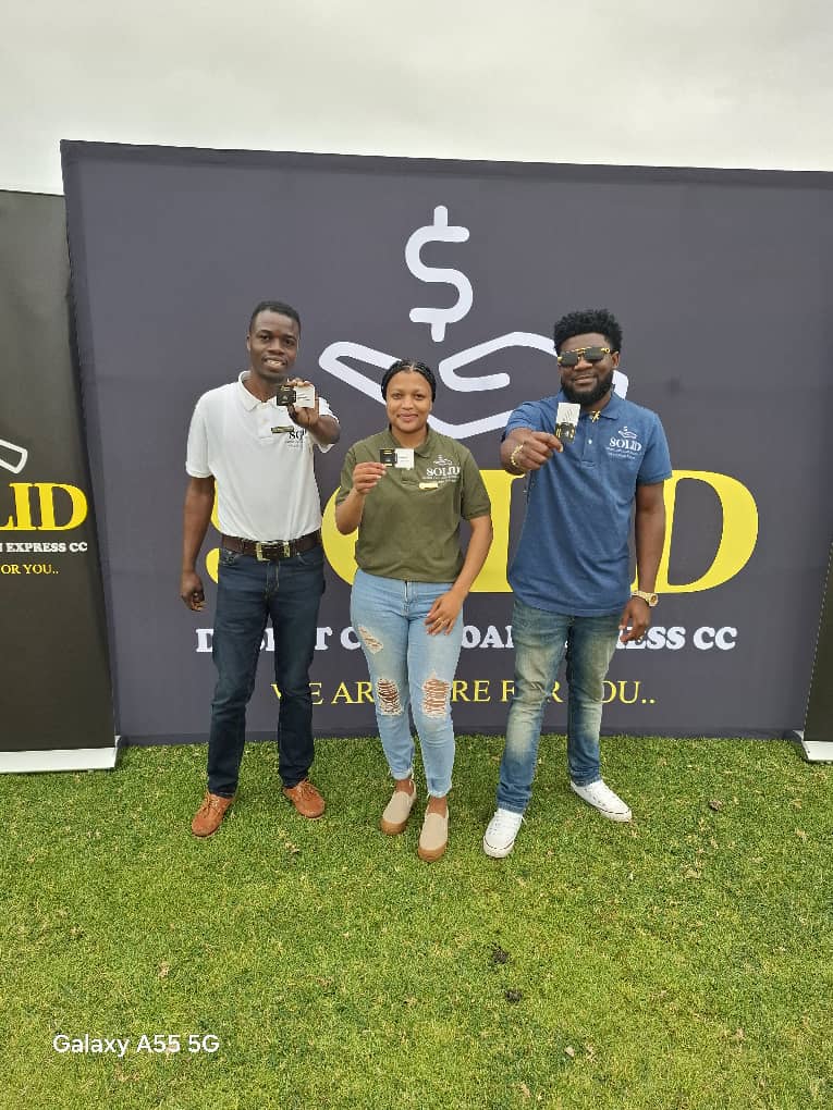 Three team members holding cards