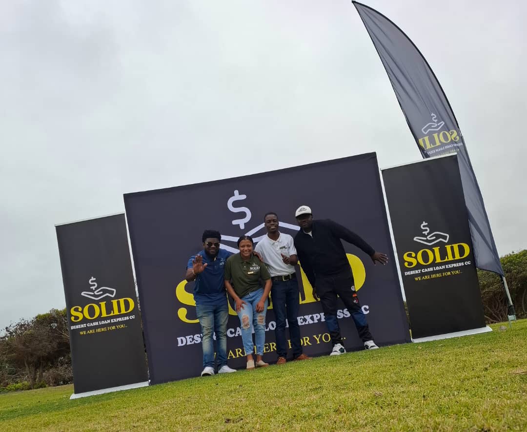 Four team members with promotional banners